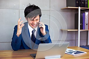 Handsome businessman gets angry so much when customer or employee is nagging him or telling some terrible things on phone.