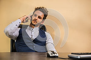 Businessman in his office talking on cell phone