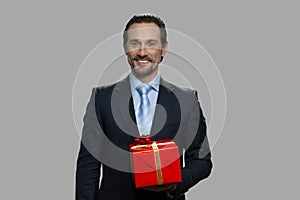 Handsome businessman holding gift box.