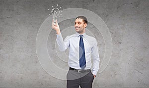 Handsome businessman holding light bulb