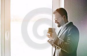 handsome businessman holding morning cup of tea or coffee, copyspace