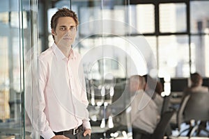 Handsome Businessman Leaning On Office Glass Door