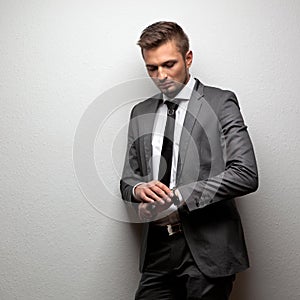 Handsome businessman look his watch on white