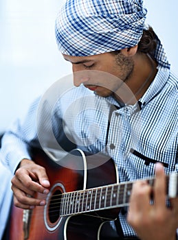 Handsome businessman playing the guitar in office