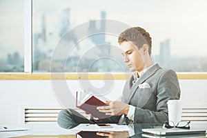 Handsome businessman reading book