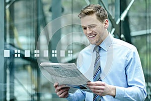 Handsome businessman reading a newspaper