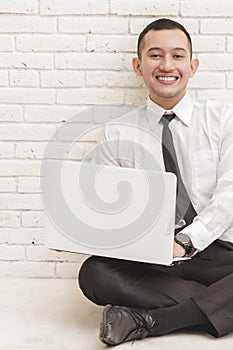 Handsome businessman relax sitting on the floor while working on