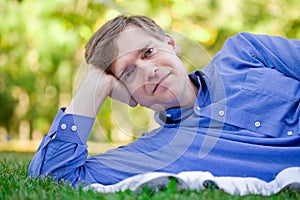 Handsome businessman relaxing on grass