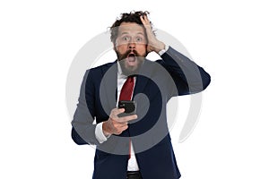 Handsome businessman slapping his head and holding a telephone