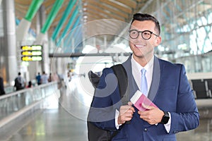 Handsome businessman smiling at the airport with space for copy