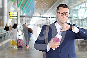 Handsome businessman smiling at the airport with space for copy
