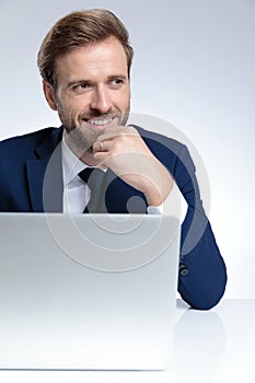 Handsome businessman smiling with his hand on his chin