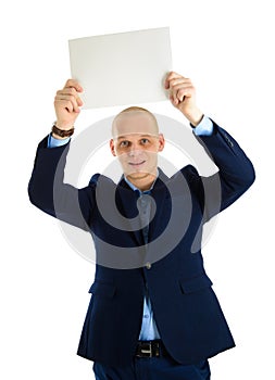 Handsome businessman in stylish suit holding empty sheet of paper over his head isolated on white background