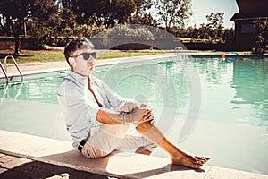 Handsome businessman takes a relaxing moment by the pool