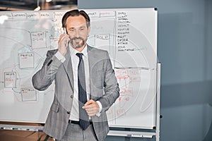 Handsome businessman talking on cellphone in office