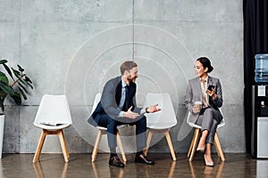 Handsome businessman talking to asian businesswoman in