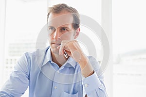 Handsome businessman thinking by the window