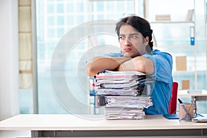 The handsome businessman unhappy with excessive work in the office