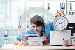 Handsome businessman unhappy with excessive work in the office