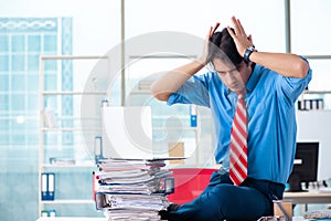 Handsome businessman unhappy with excessive work in the office