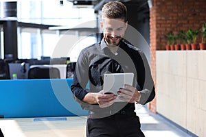 Handsome businessman using his tablet in the office