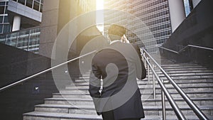 A handsome businessman walking up stairs and having phone conversation.