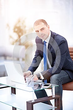 Handsome businessman working with laptop in office