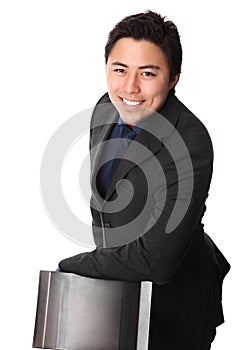 Handsome businessperson in suit leaning against a chair