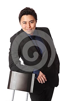 Handsome businessperson in suit leaning against a chair