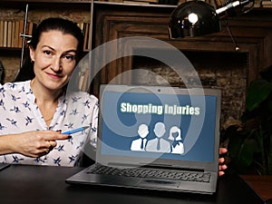 A handsome businessWoman showing a laptop with sign Shopping Injuries . Close-up shot. Soft focus