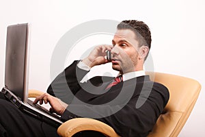 Handsome calling businessman with laptop