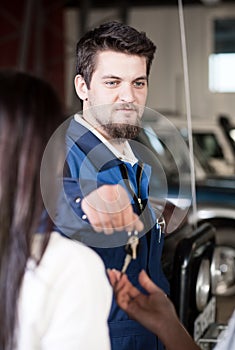 Handsome car mecanic giving back the keys