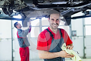 Car mechanic working at automotive service center photo