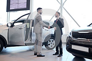 Handsome Car Salesman Shaking Hands with Client