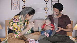 A handsome caring father feeding with milk bottle to his little daughter - Indian family, nuclear family