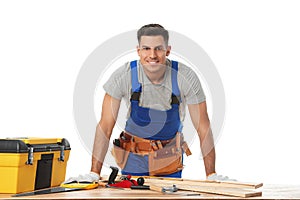 Handsome carpenter working with timber at table on white background