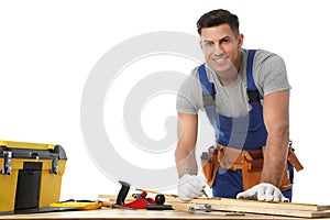 Handsome carpenter working with timber at table on white background