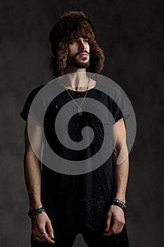 Handsome casual man looking to side on grey background