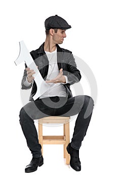 Seated casual man presenting number one to a side cocky photo