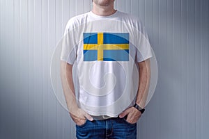 Handsome casual man wearing white t-shirt with Swedish flag