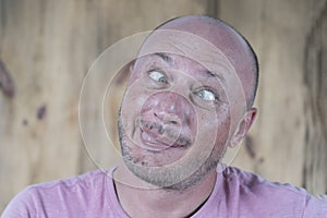 Handsome caucasian bald man making funny face, close up