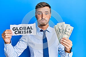 Handsome caucasian business man holding dollars on global crisis puffing cheeks with funny face