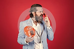 handsome caucasian businessman with trendy hairstyle in jacket speak on vintage phone, anger