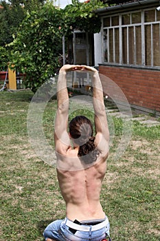 Handsome caucasian guy is working out in the nature.  Gymnastics, healthy lifestyle concept.