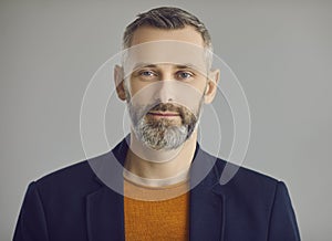 Handsome caucasian hipster man with beard face portrait on grey background