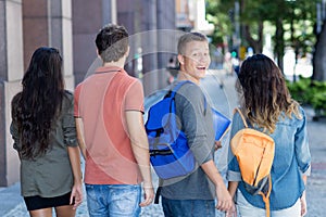 Handsome caucasian male student with group of young adults outdoor in city