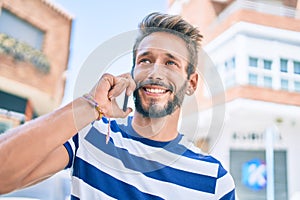 Handsome caucasian man with beard smiling happy outdoors speaking on the phone