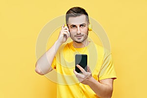 Handsome caucasian man listening to music from his phone and headphones