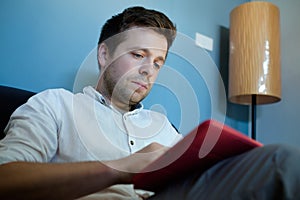 Handsome caucasian man using his tablet sitting on a couch