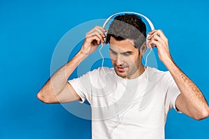 Handsome Caucasian man wearing headphones to listen to music